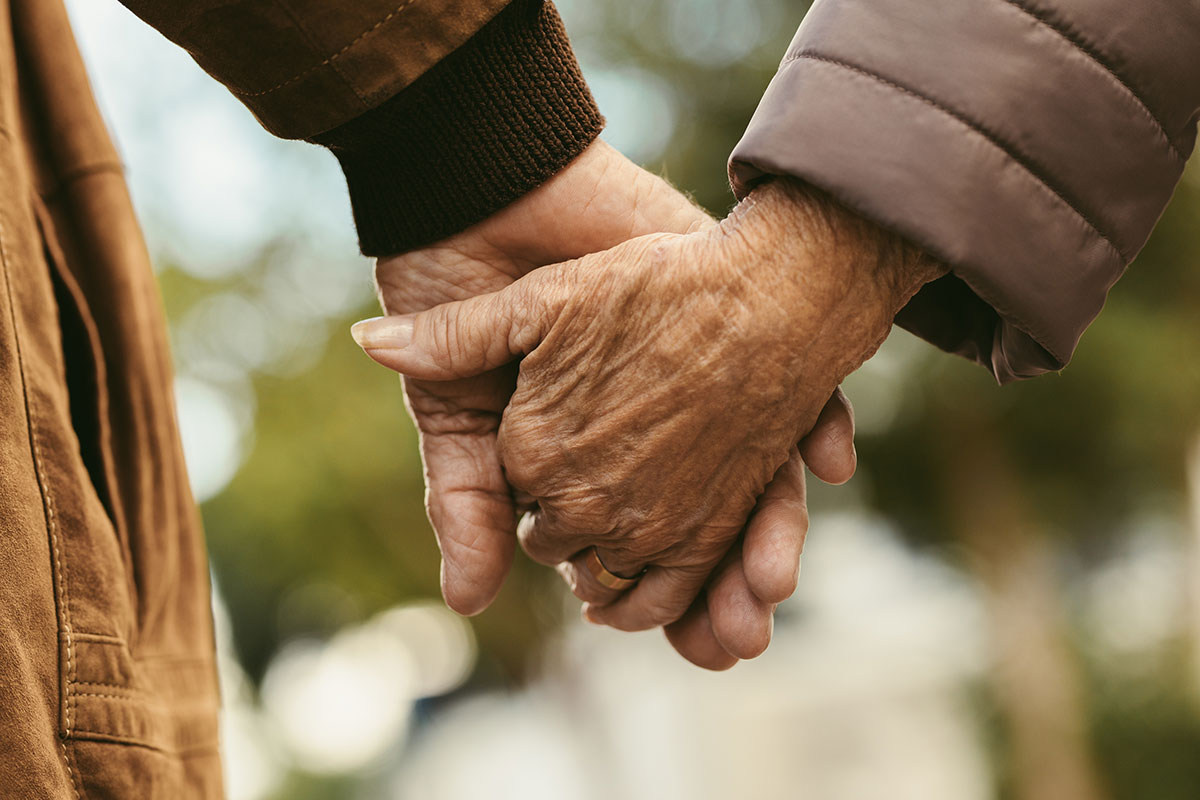 Ältere Menschen halten sich die Hand